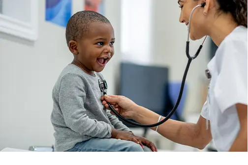 Joyful child being examined by a pediatrician