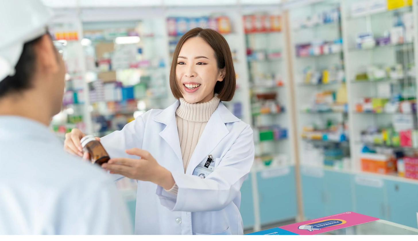 Friendly pharmacist helping a customer at the counter
