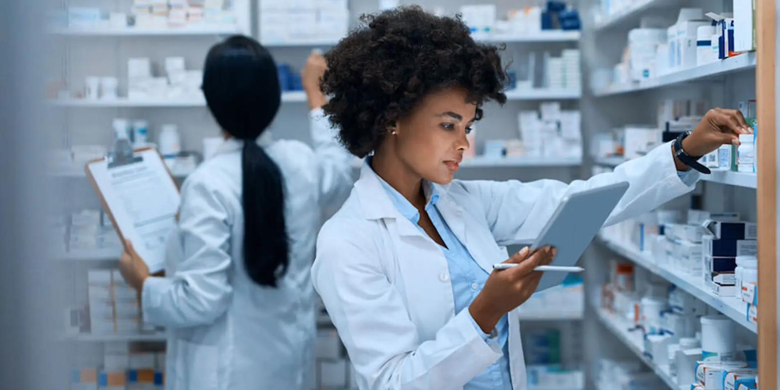 Pharmacist reviewing inventory with a tablet